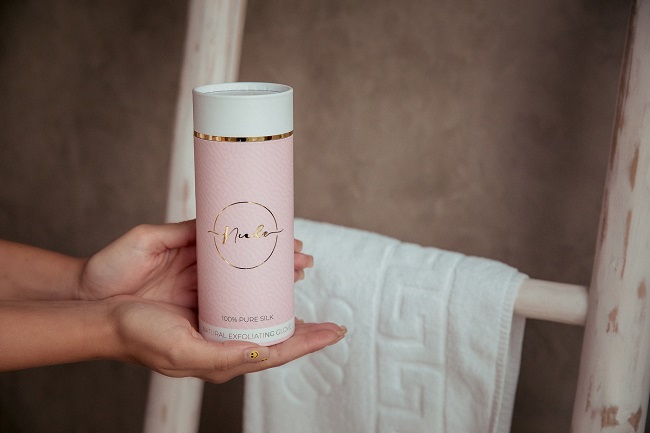 Mănușa exfoliantă Nude în ambalajul sub formă de tub.