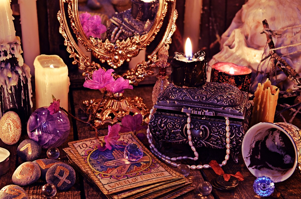 Ritual de magie neagră sau vrajă efectuat cu ajutorul cărților de tarot și al obiectelor oculte, ezoterice, așezate pe masa unei vrăjitoare.