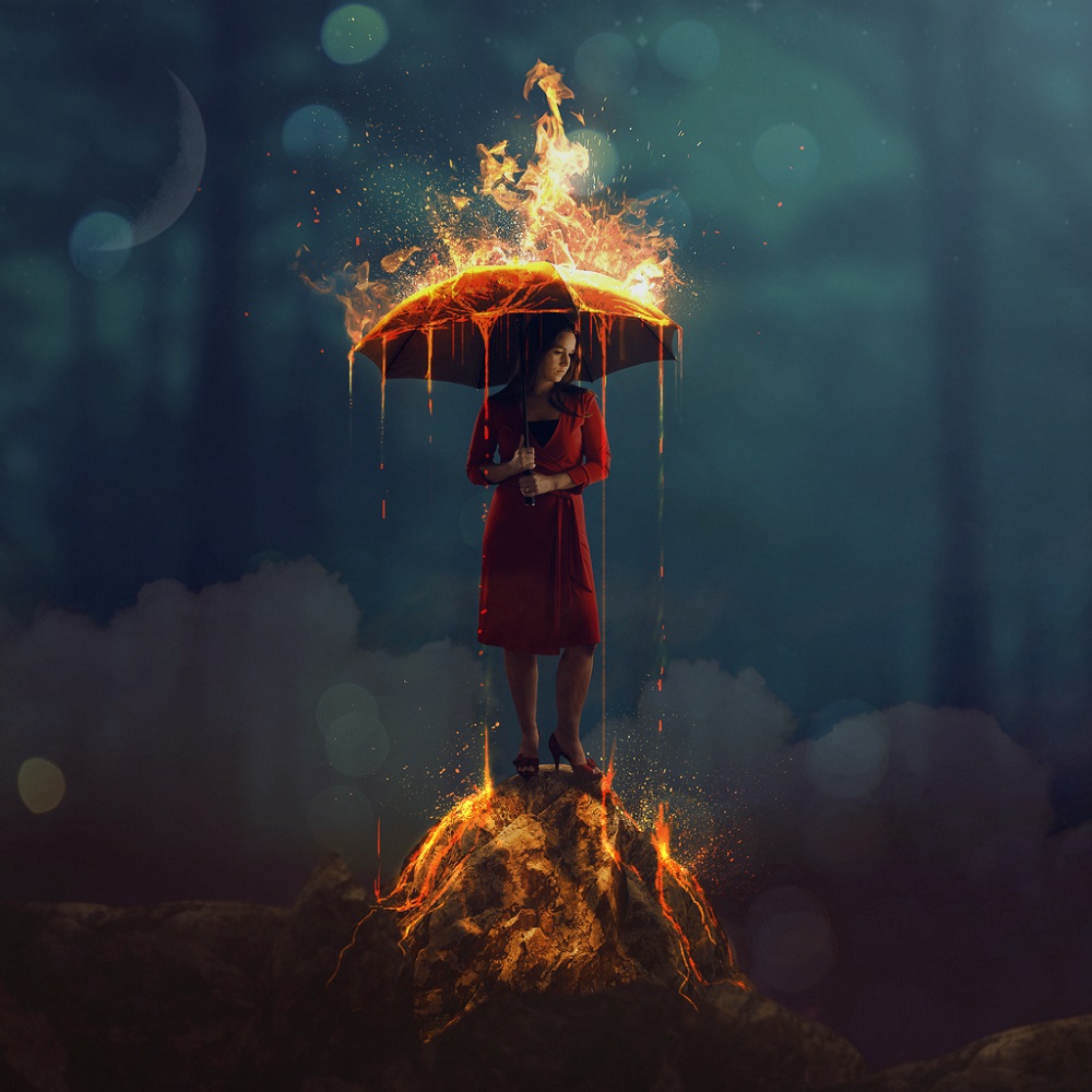 Femeie în rochie roșie care se apără de foc, folosindu-se de o umbrelă.