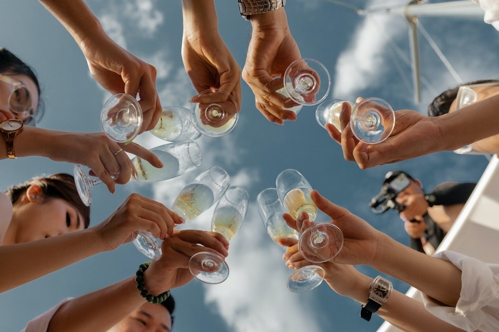 Invitați la nuntă care ciocnesc paharele de șampanie.