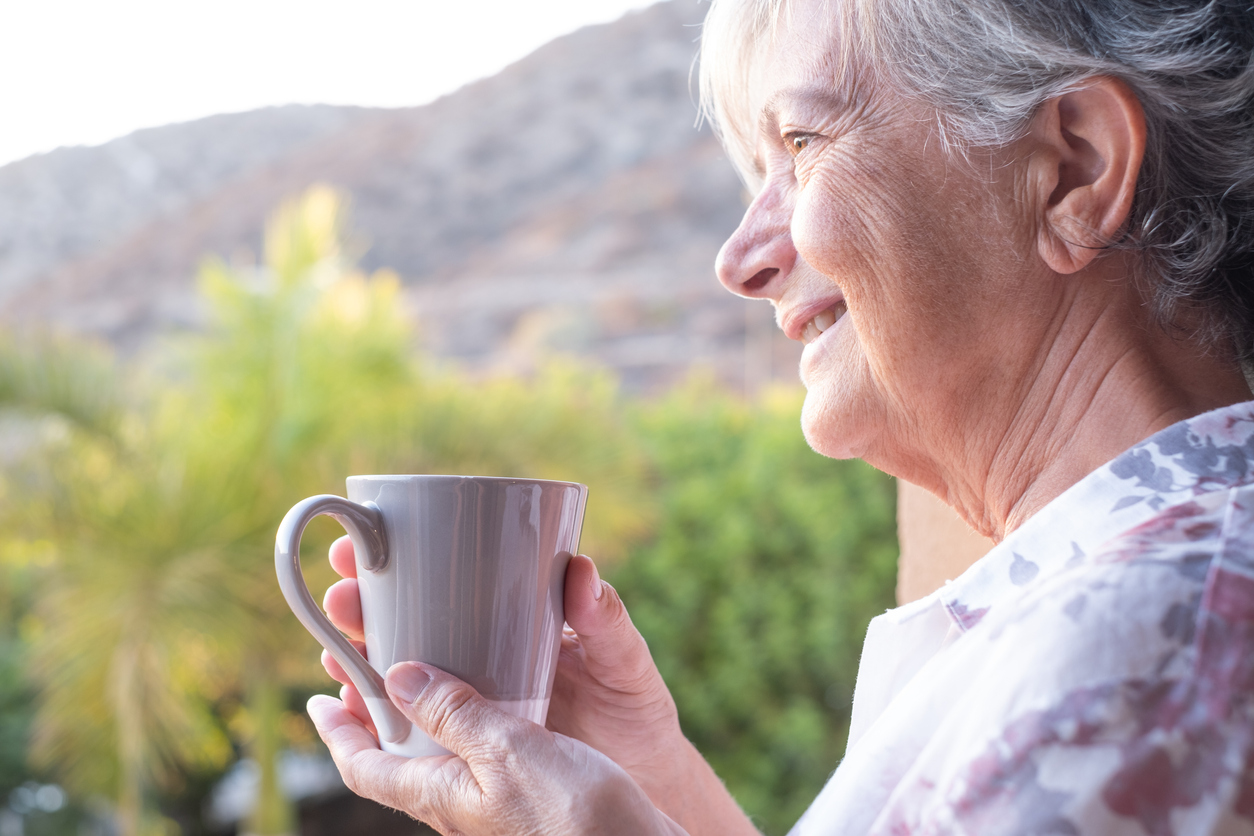 Femeie în vârstă care bea cafea