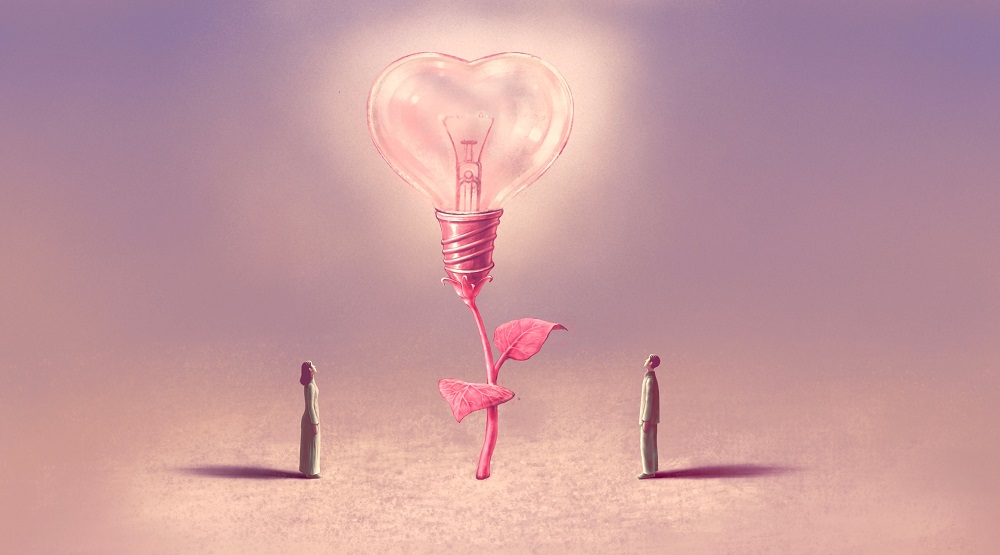 Doi oameni care privesc un bec în formă de inimă - o ilustrație a iubirii care se înalță ca o floare hrănită de lumină.