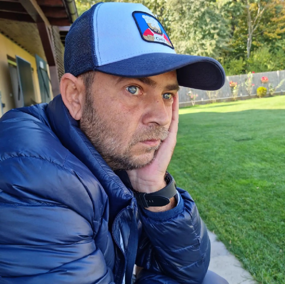 Actorul Cosmin Seleși gânditor, uitându-se în gol, cu o șapcă pe cap.