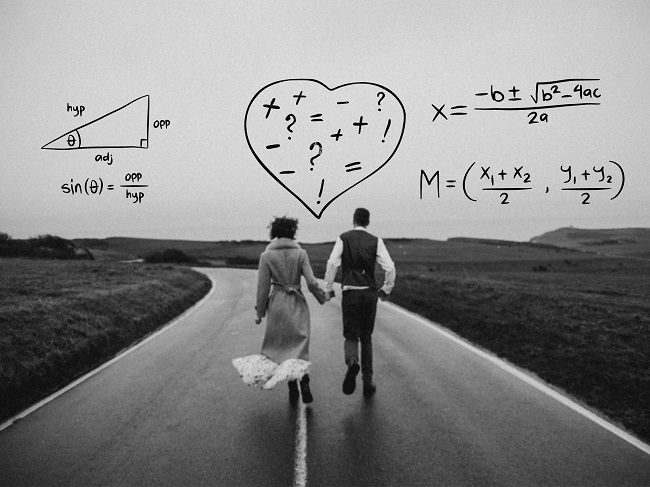 Imagine alb-negru cu un cuplu care se plimbă de mână pe o șosea pustie.