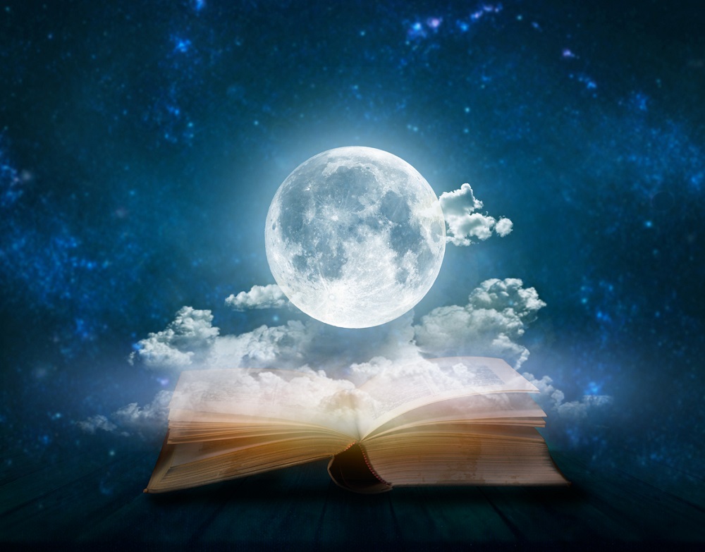 Luna Plină aflată deasupra unei cărți deschise.