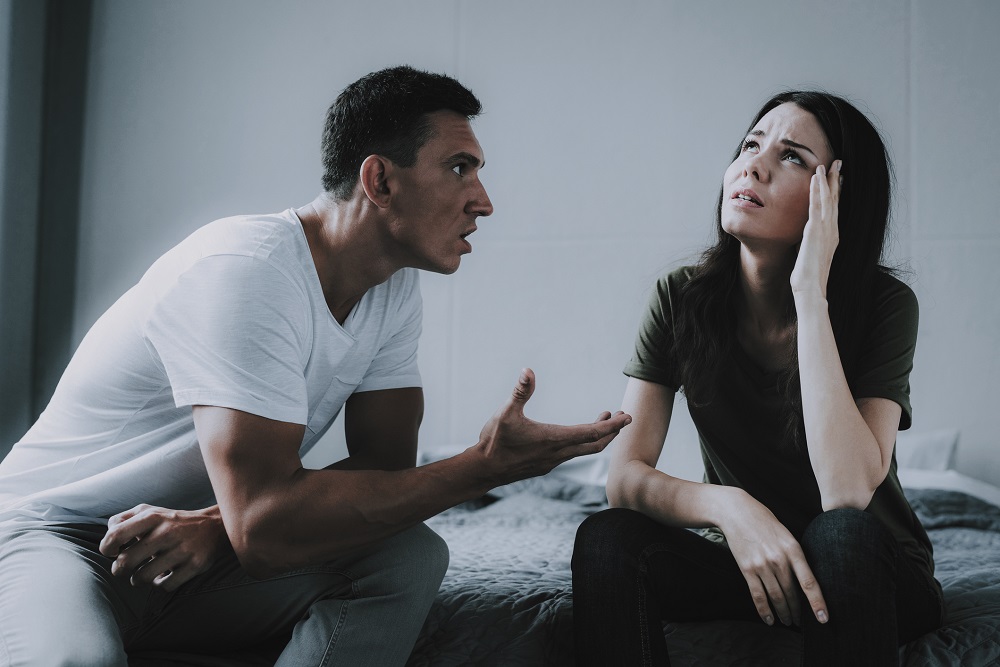 Cuplu care se ceartă, în timp ce femeia pare dezamăgită de atitudinea bărbatului.