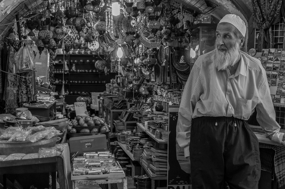 Imagine alb-negru cu un evreu care vinde la un magazin cu suveniruri