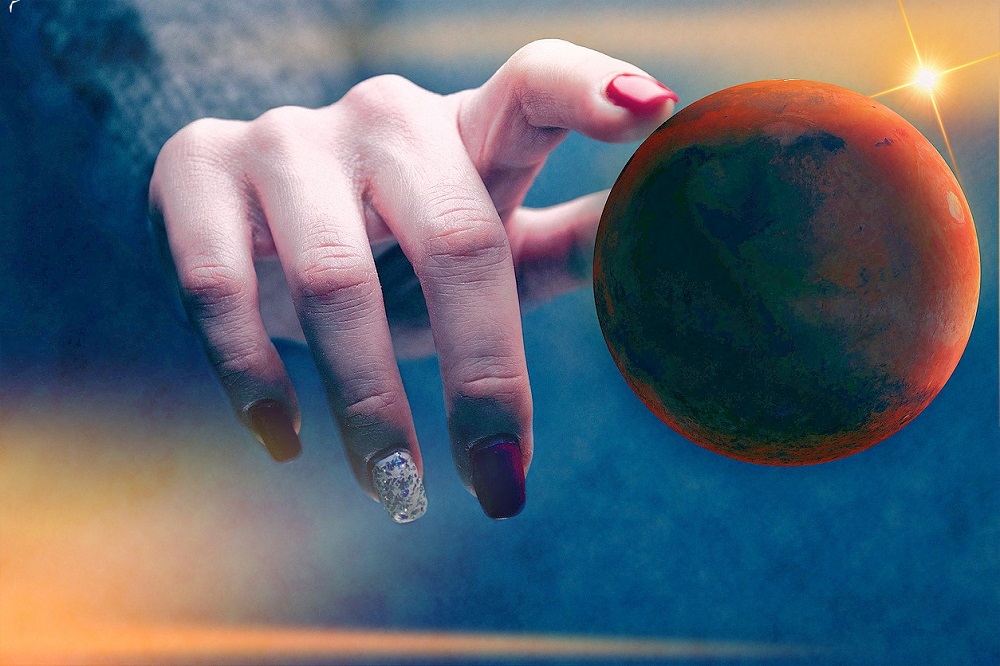 Ilustrație cu o femeie care atinge planeta Marte cu degetul.