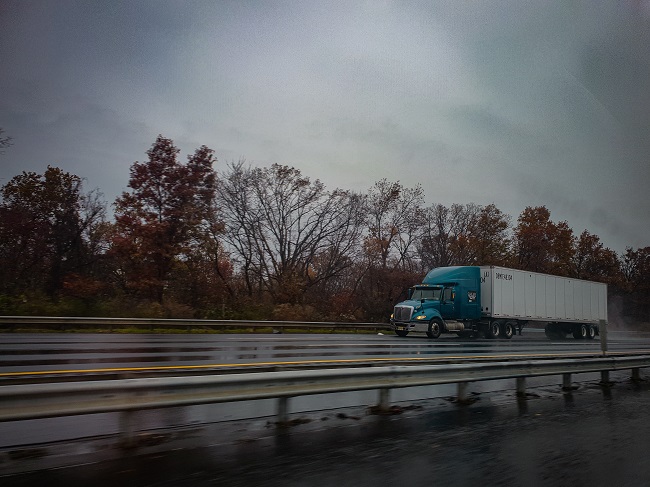 Camion pe carosabil într-o zi ploioasă.