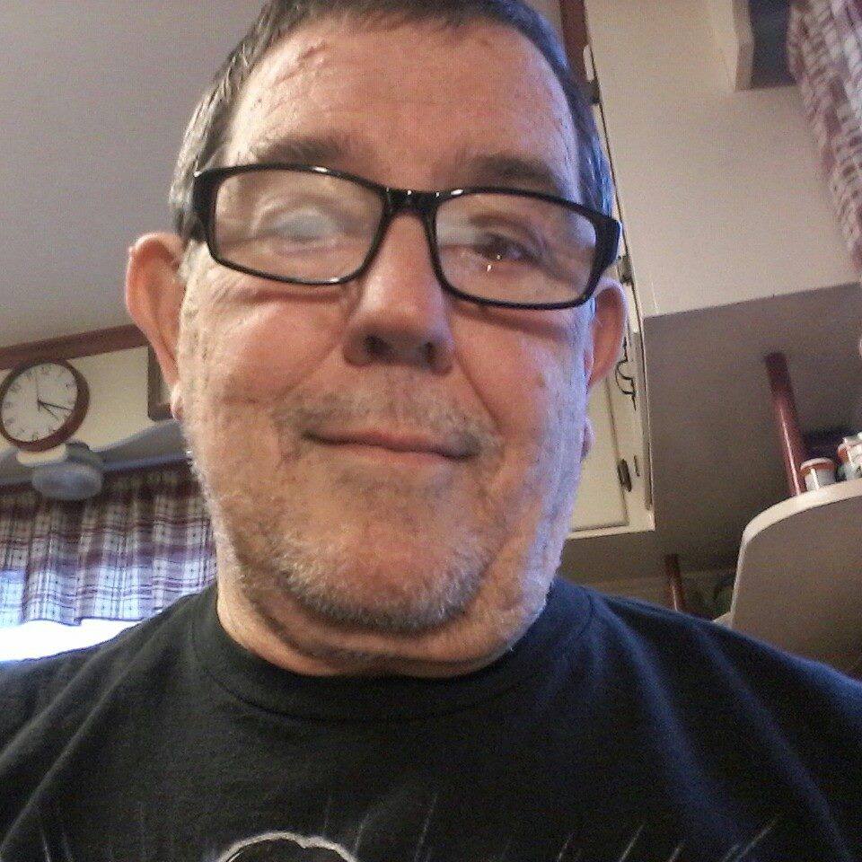 Andy Fierlit zâmbitor, purtând ochelari de vedere și un tricou negru