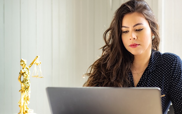 Femeie concentrată la munca pe care o face pe laptop.