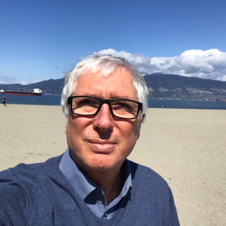 Regizorul italian Franco Amurri (64 de ani) pe o plajă, cu marea în spate.