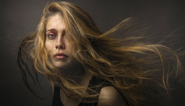 Portretul unei femei triste cu părul lung, care poartă un top negru