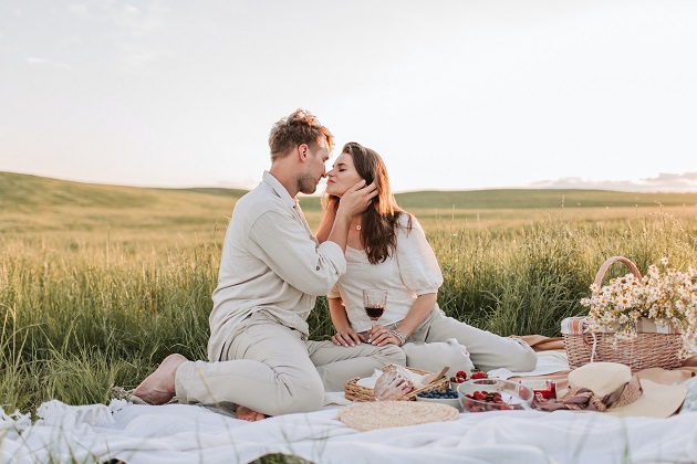 Parteneri care se sărută în timpul unui picnic.