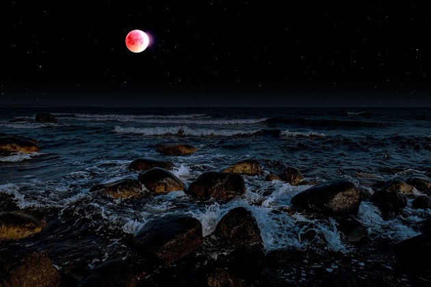 Luna Plină luminează deasupra mării agitate care se lovește cu putere de țărm