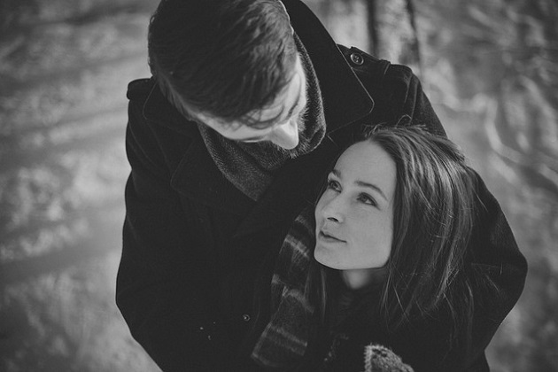 Imagine alb-negru cu un cuplu îmbrățișat într-o zi friguroasă.