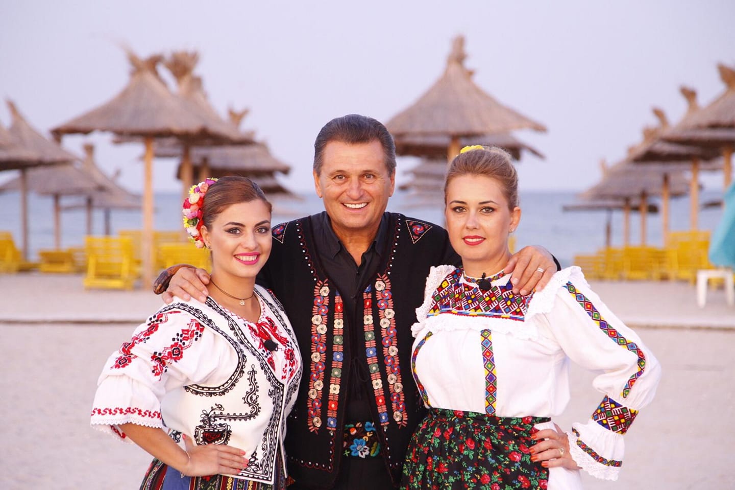Marin Barbu, alături de fiicele sale, Larisa și Dana, îmbrăcați în costume populare pe plajă.