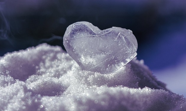 Inimă de gheață așezată pe zăpadă