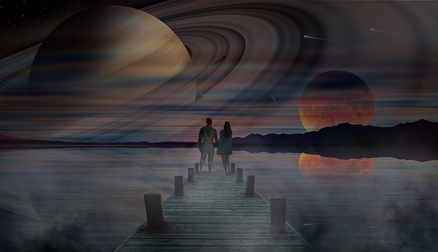 Parteneri care se țin de mână și stau pe un ponton pentru a admira priveliștea, în timp ce imaginea cerului se reflectă în lac