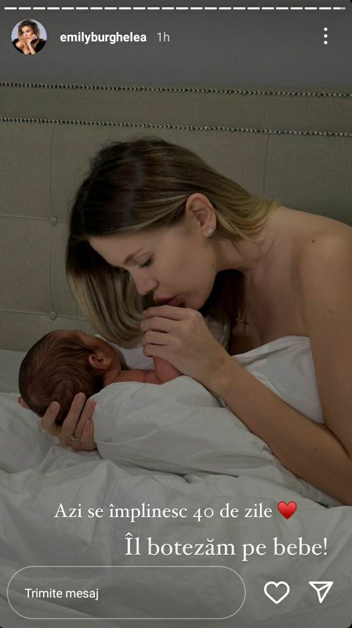 Emily Burghelea în timp ce stă în pat, în așternuturi albe și sărută mâna bebelușului ei la 40 de zile de viață.