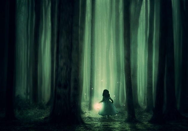 Fetiță îmbrăcată în rochie de prințesă care merge spre lumină prin pădurea întunecată