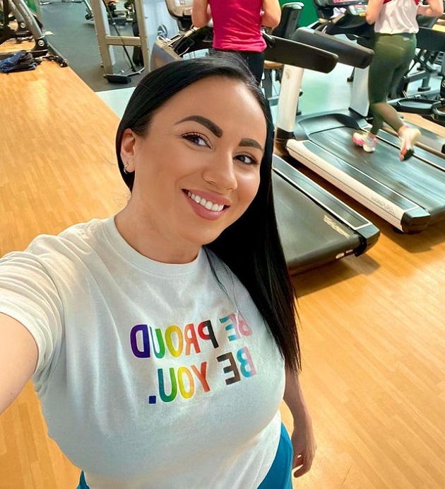 Rocsana Marcu într-un tricou alb și cu pletele lungi desprinse în sala de sport