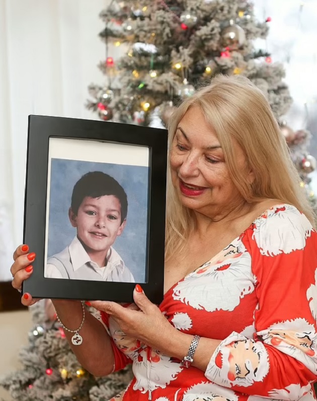 Joyce Curtis lângă bradul de Crăciun, ținând în mână tabloul fiului său de când era mic