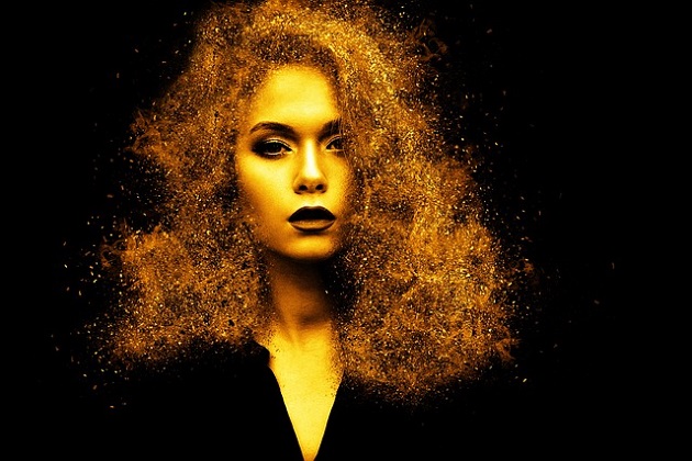 Portret al unei femei care are părul acoperit de sclipici auriu
