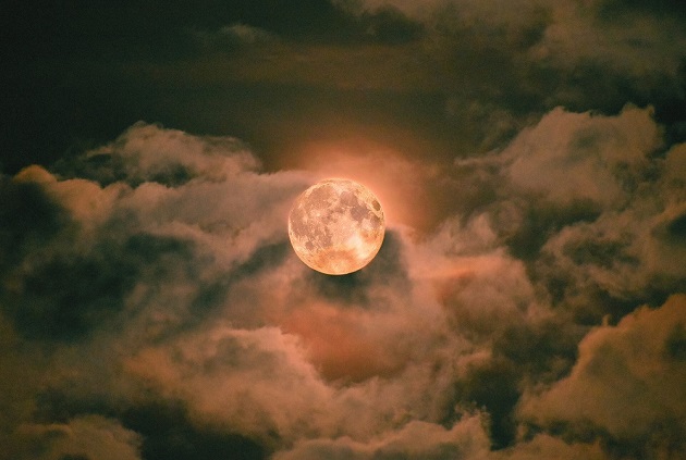 Luna Plină care strălucește puternic printre nori