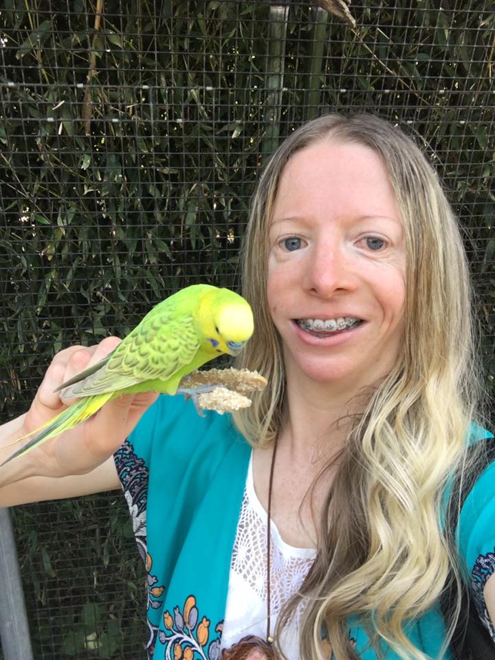 Cynthia Murphy în 2017, ținând un papagal verde în mână