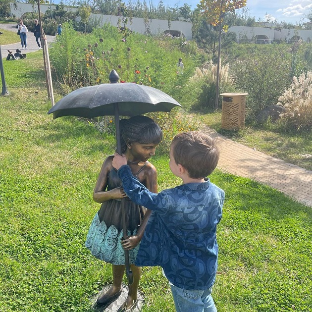 Alexandru Bănică, fiul Laviniei Pîrva și al lui Ștefan Bănică Junior, jucându-se cu statuia unei fetițe cu umbrelă