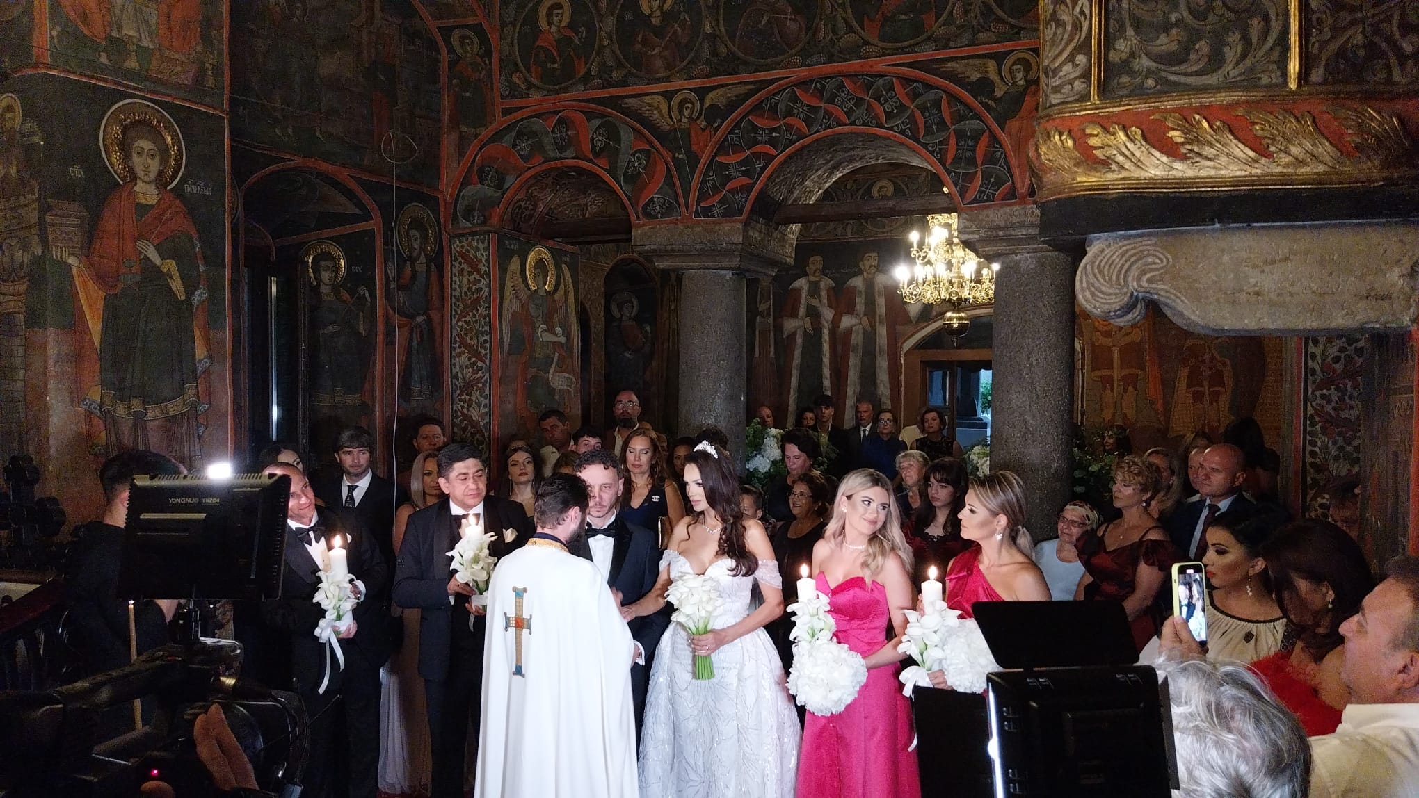 Cristina Spătar și soțul ei în timpul cununiei religioase, alături de apropiații lor.