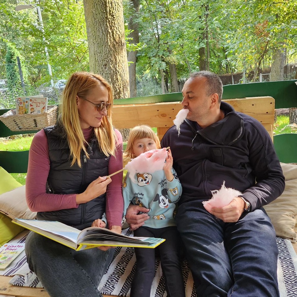 Camelia Potec alături de soțul ei și fiica lor, mâncând vată pe băț de ziua copiilor.