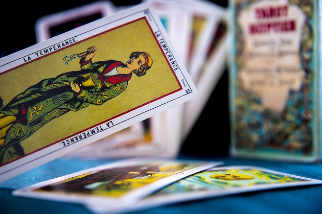 Imagine cu mai multe cărți de Tarot, printre care și Cumpărarea, așezată în prim-plan