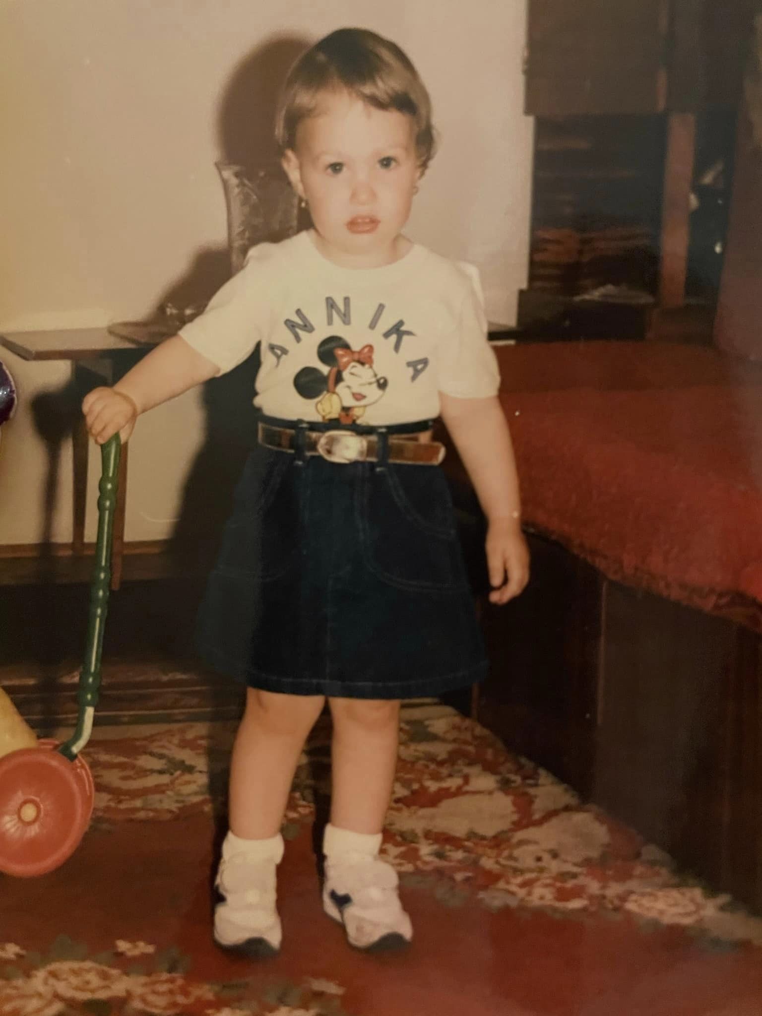 Fiica Marinei Almășan când era mică, îmbrăcată într-o fustă de blugi și într-un tricou cu Minnie Mouse