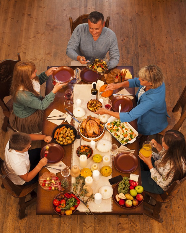 Familie numeroasă care s-a strâns în jurul unei mese bogate în zi de sărbătoare