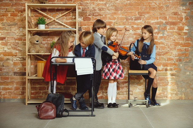 Copii care se învață unul pe altul să cânte la vioară