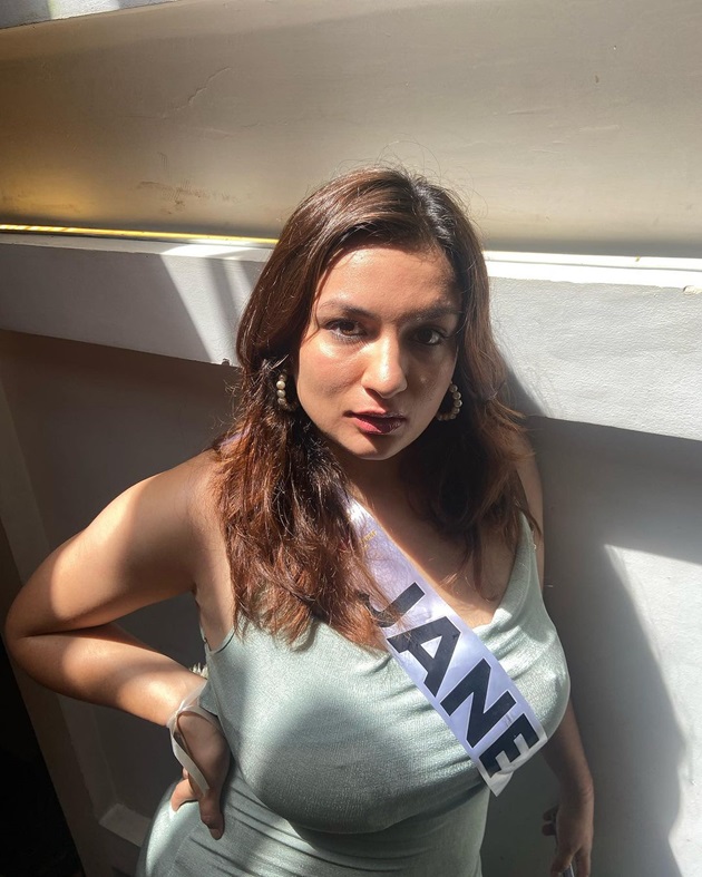 Jane Dipika Garrett, Miss Nepal 2023 îmbrăcată într-o rochie mulată cu bretele, în timpul unui eveniment în cadrul căruia poartă o banderolă cu prenumele ei.