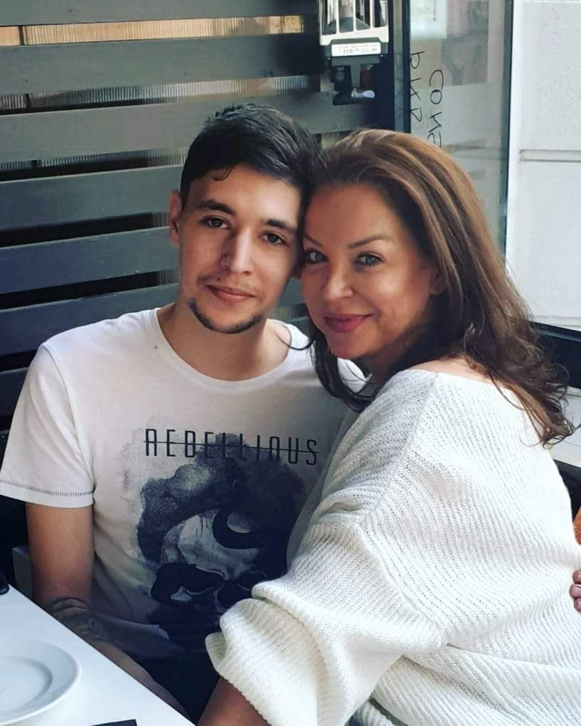 Eugenia Șerban îmbrățișându-l pe fiul ei, Lorans Bataineh, în timp ce stau amândoi la aceeași masă.