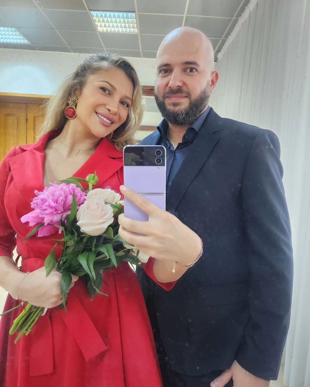 Lora și iubitul ei Ionuț Ghenu la nunta surorii acestuia, îmbrăcați elegant, în timp ce s-au fotografiat într-o oglindă