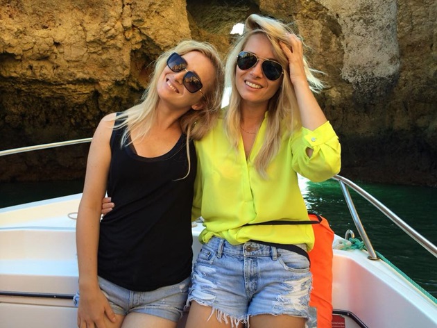 Laura Cosoi și Alina Cosoi îmbrăcate în haine de vară, purtând ochelari de soare, pe o barcă