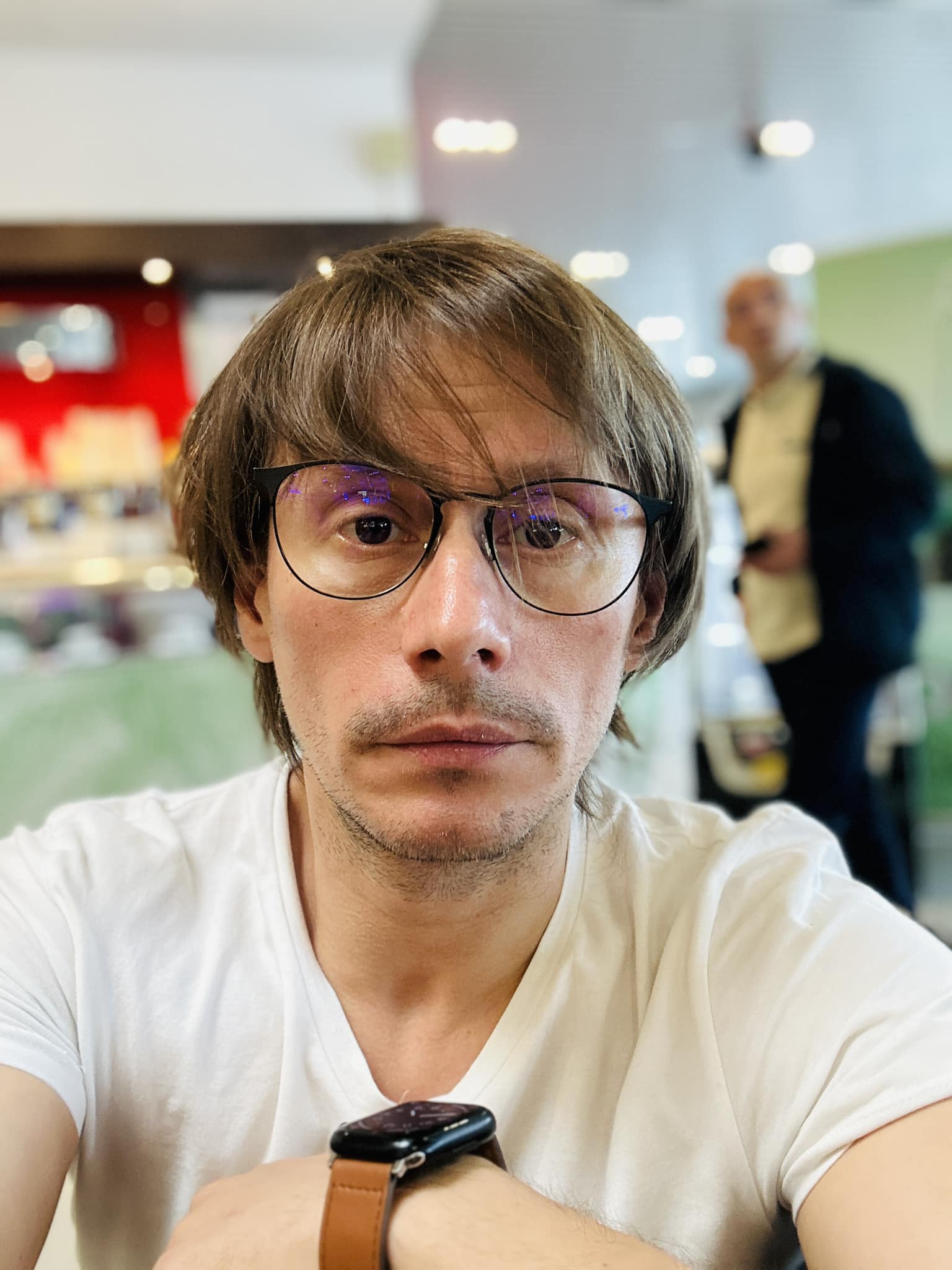 Marius Manole cu ochelari și ceas la mână, îmbrăcat într-un tricou alb.