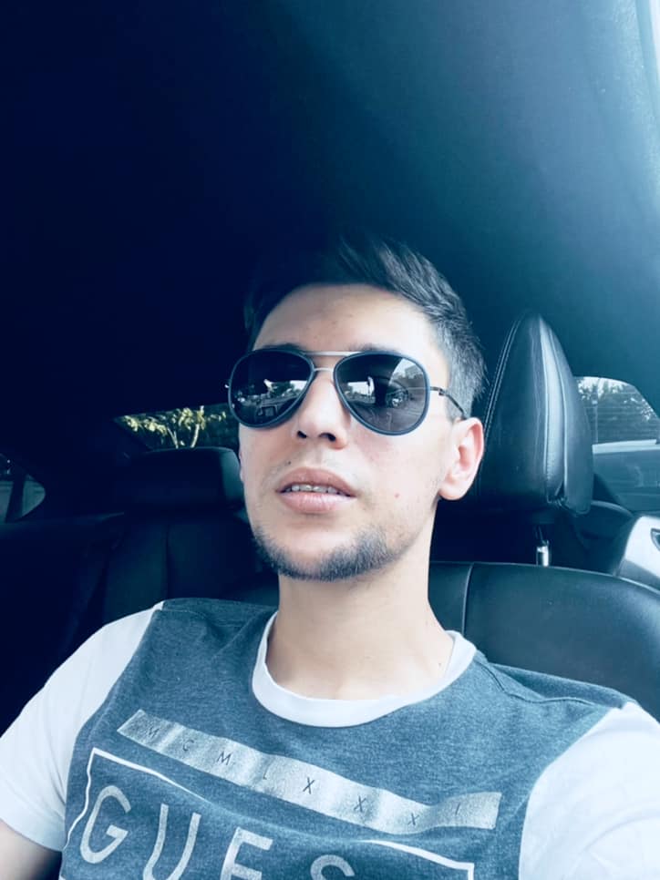 Lorans Bataineh, fiul Eugeniei Șerban, stând în mașină, cu ochelarii de soare la ochi