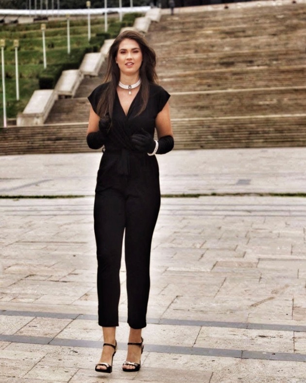 Alexandra Dominique Lăcătuș într-o salopetă neagră, asortată cu sandalele negre și accesorizată cu bijuterii din perle