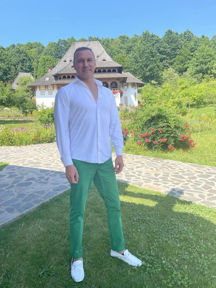 Alin Oprea la un eveniment, îmbrăcat în pantaloni verzi și cămași albă