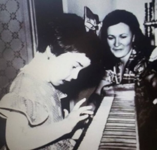 Andreea Marin în copilărie, cântând la pian, în timp ce mama ei o privea