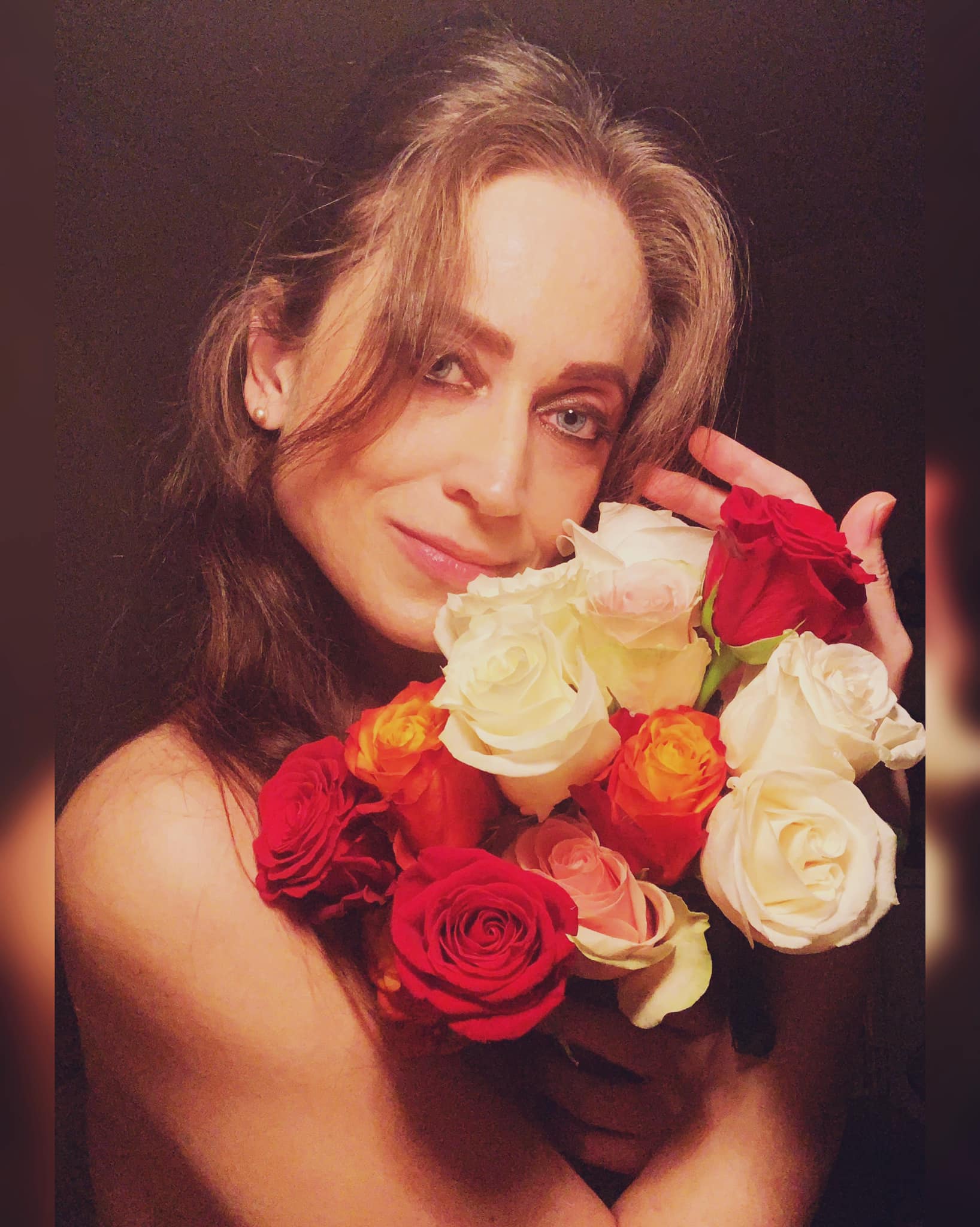 Irina Rădulescu ținând în brațe un buchet de trandafiri colorați