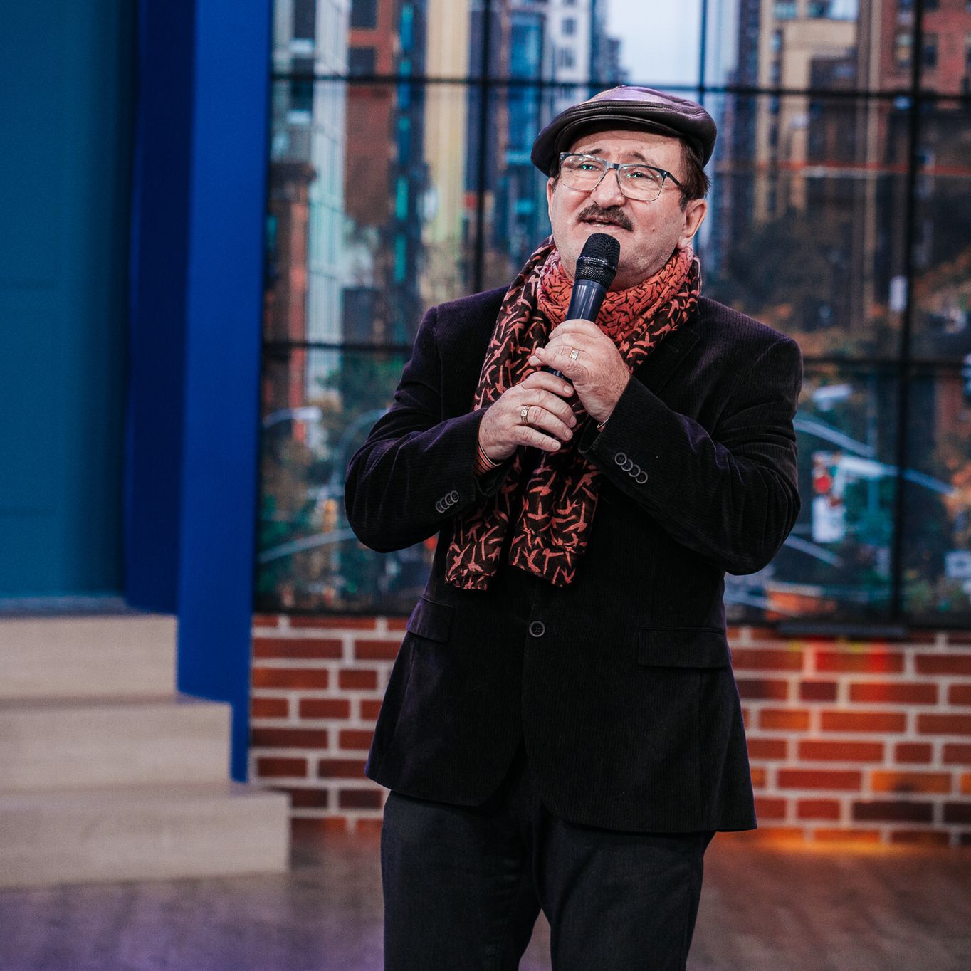 Cornel Palade în platoul emisiunii „La Măruță” cu microfonul în mână.