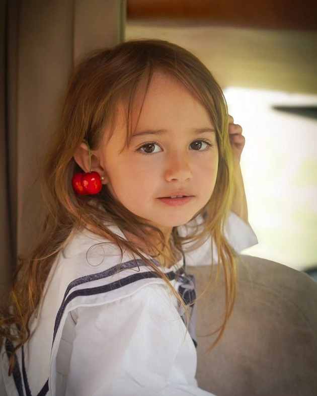 Lia Dragomir într-o rochie albă, cu cireșe în urechi