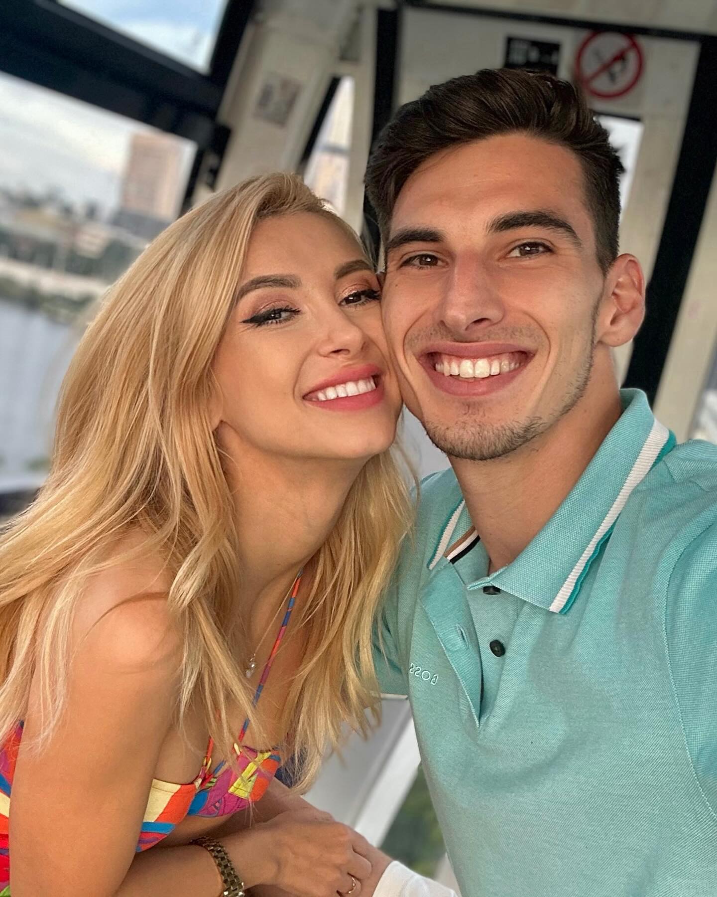 Andreea Bălan și Victor Cornea cu fețele apropiate, zâmbitori și îmbrăcați colorat.